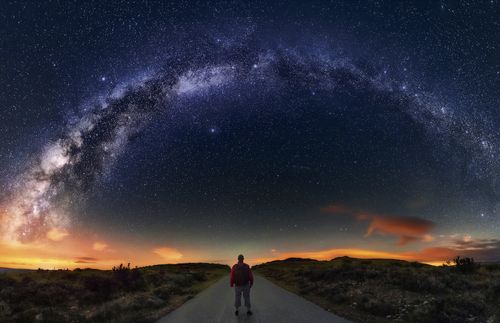 man looking up at sky at night