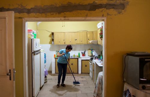 Blanca sweeping the kitchen