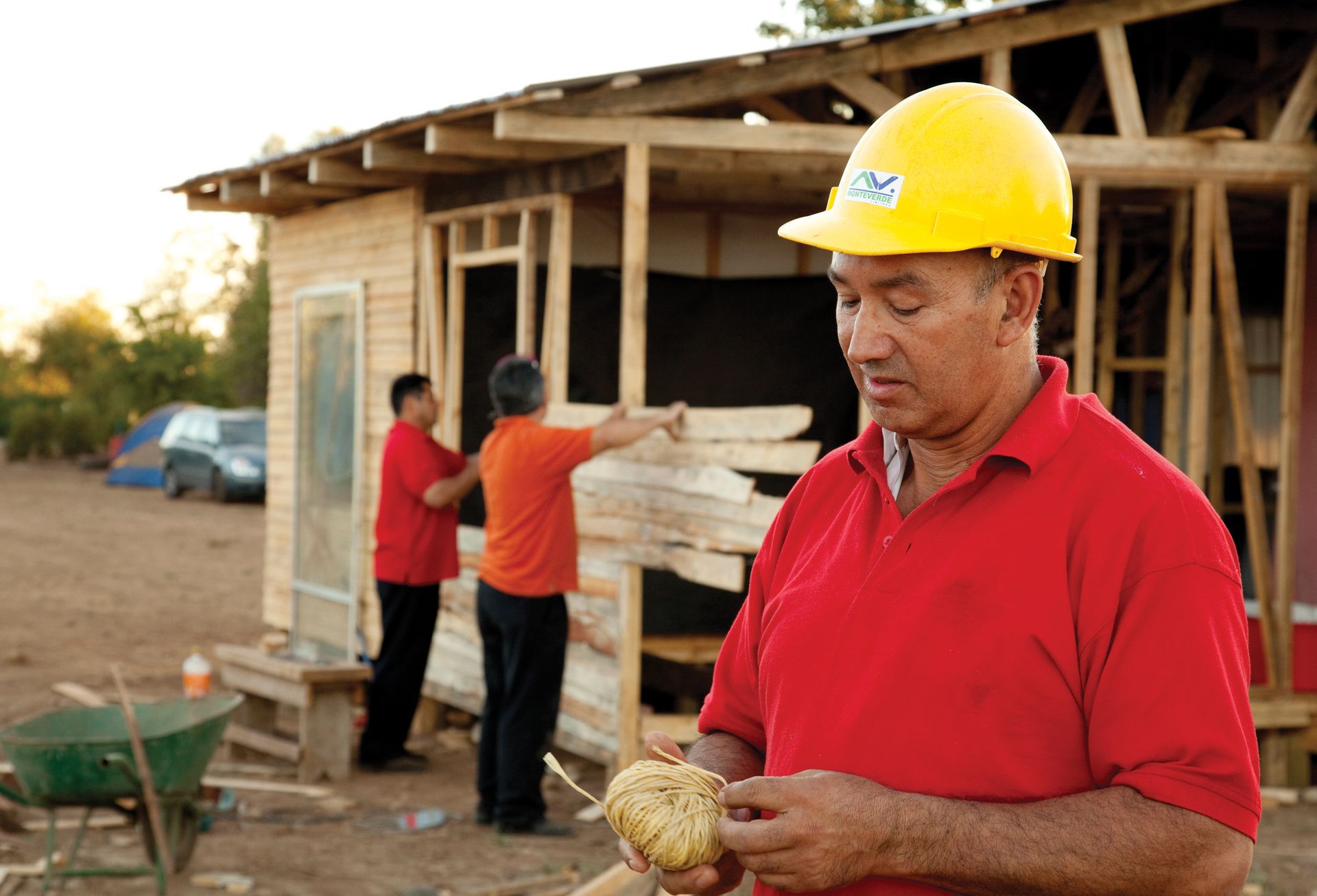 A group of men help rebuild a home after a natural disaster.