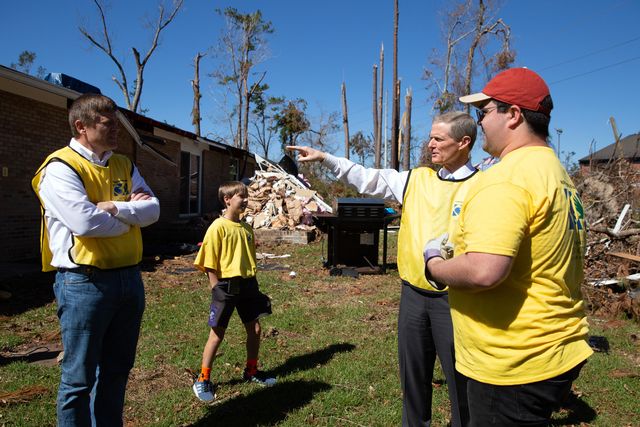Elder David A. Bednar is outside. He is wearing a yellow Helping Hands vest. He is talking with other volunteers who are working. They are in Mariana, Florida on October 21, 2018.&nbsp;