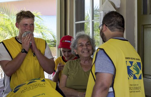 men in Helping Hands vests giving service