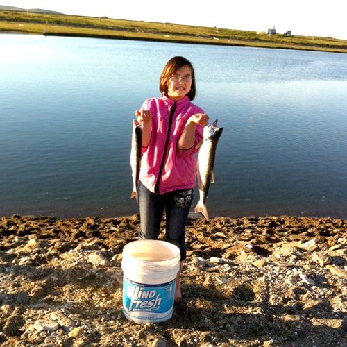 girl holding up two fish