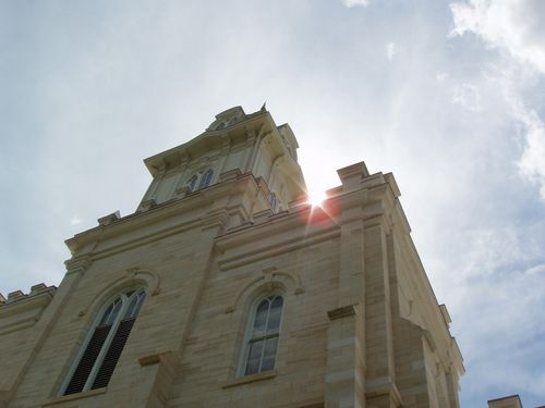 A worm’s-eye view, looking up toward the sun shining past the spire of the Manti Utah Temple.