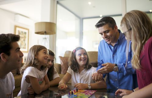 Family playing games on table in Portugal