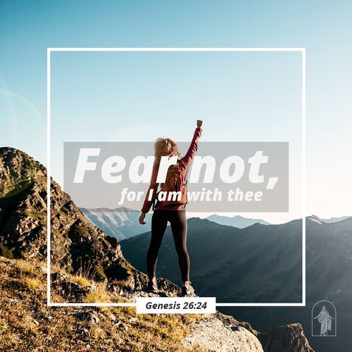 young woman standing on a mountain raising her fist in the air