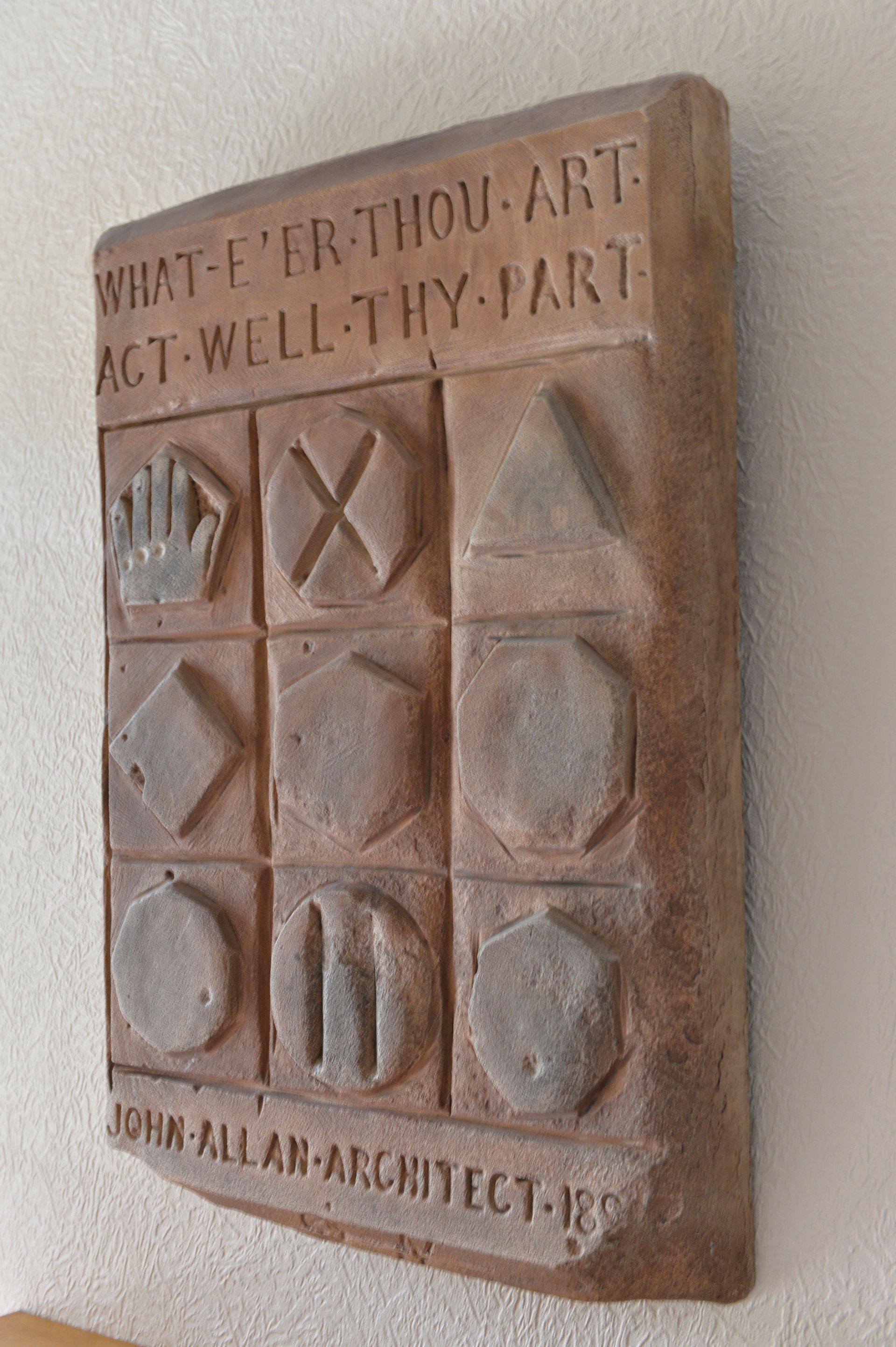 A replica of the plaque with the statement “What E’er Thou Art, Act Well Thy Part.”