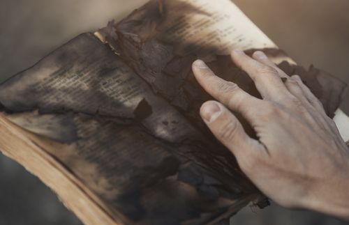 hand touching a burned book