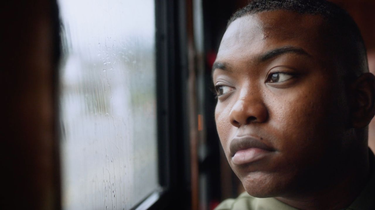 A young man looks out a rainy window thinking about forgiveness