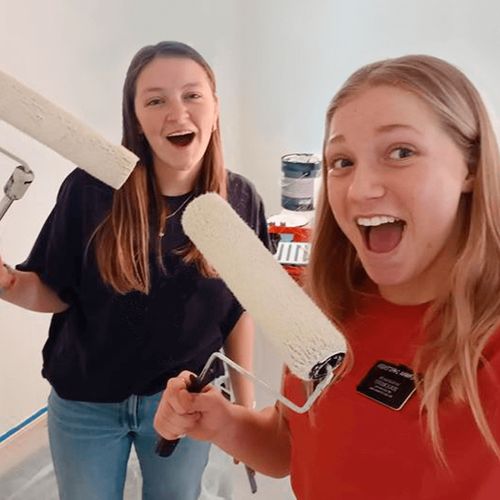 sister missionaries with paint rollers