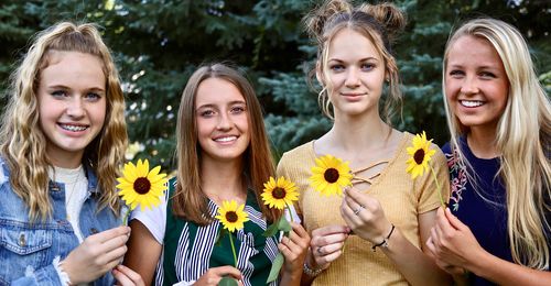 girls holding sunflowers