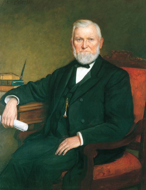A painting by H. E. Peterson of President Wilford Woodruff in a black suit sitting in a red armchair and resting one arm on a table.