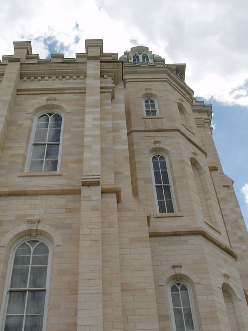 A low-angle view of one wall of windows on the Manti Utah Temple exterior.