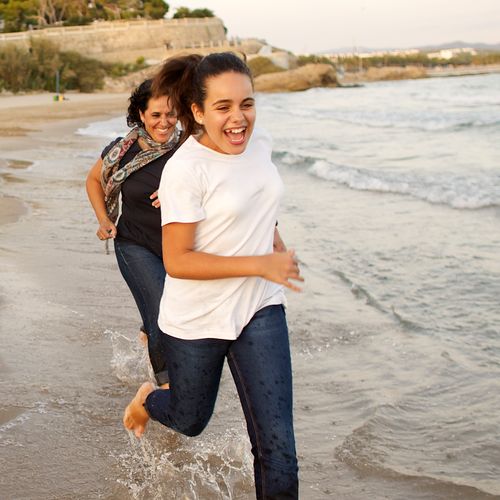 mother and daughter running on beach