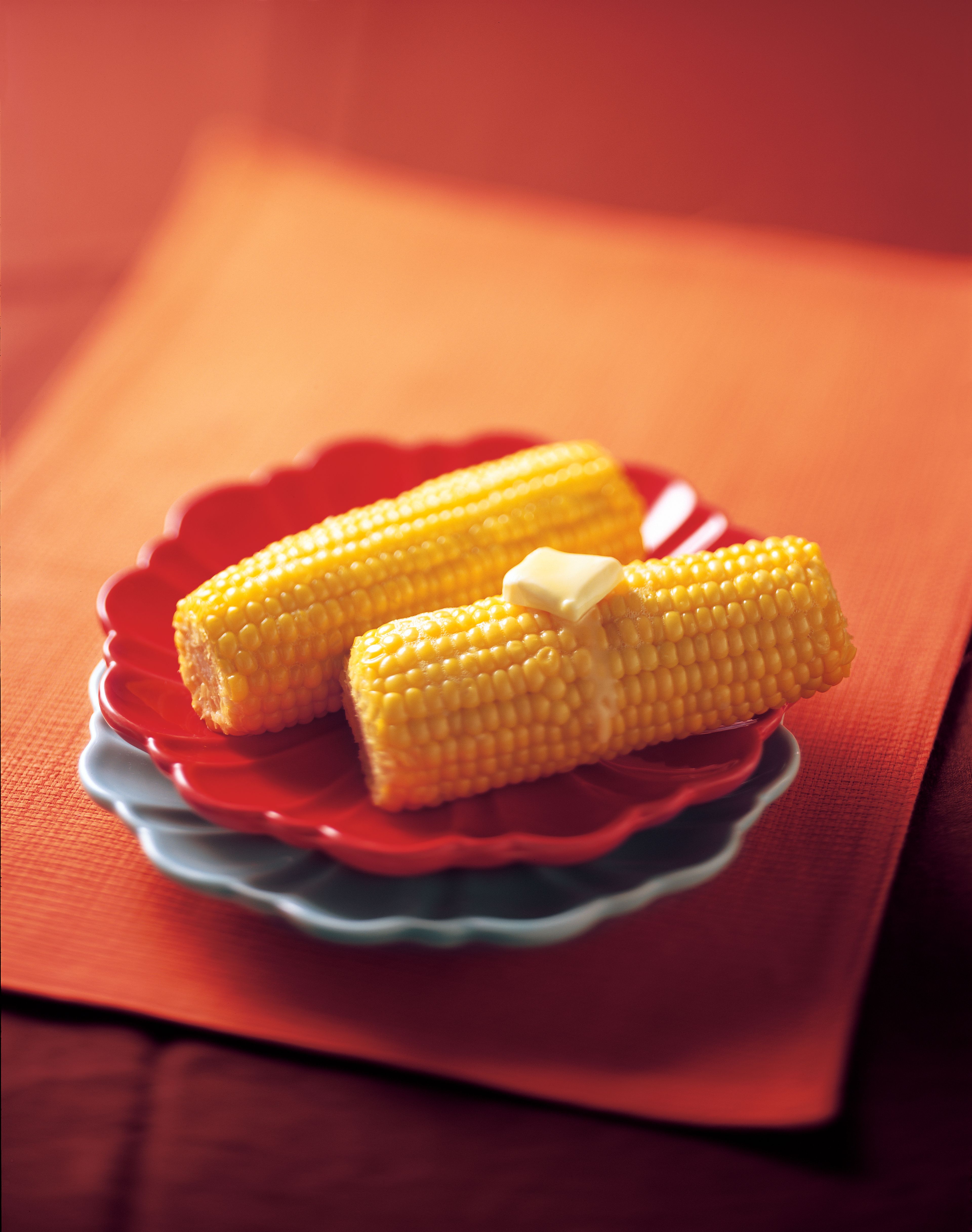Fresh corn on the cob with butter on top.