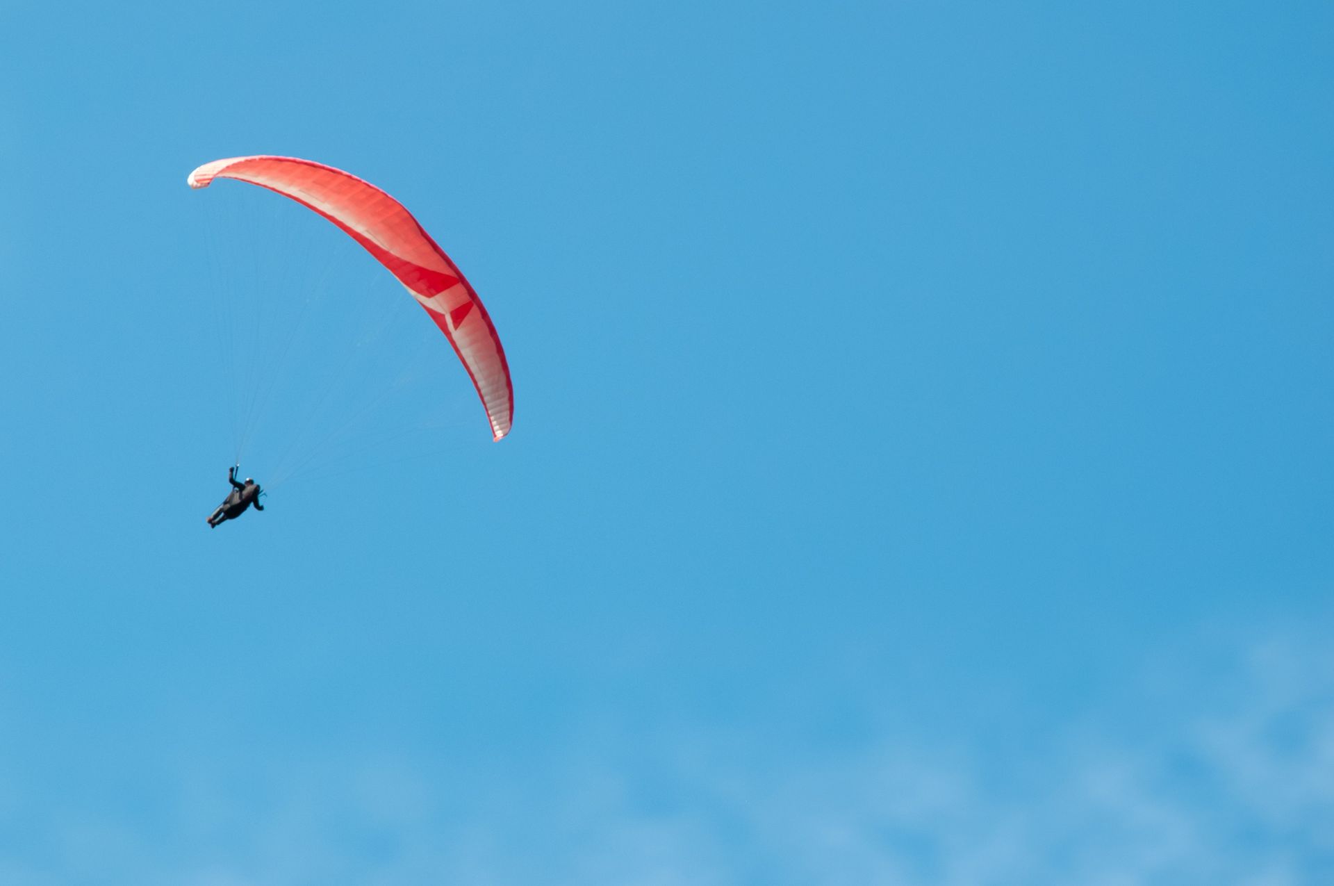 A person goes hang gliding for recreation.