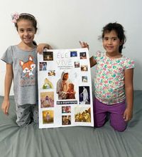 sisters holding up art of Jesus