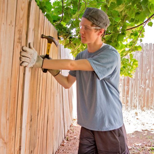 Young man fixing fence