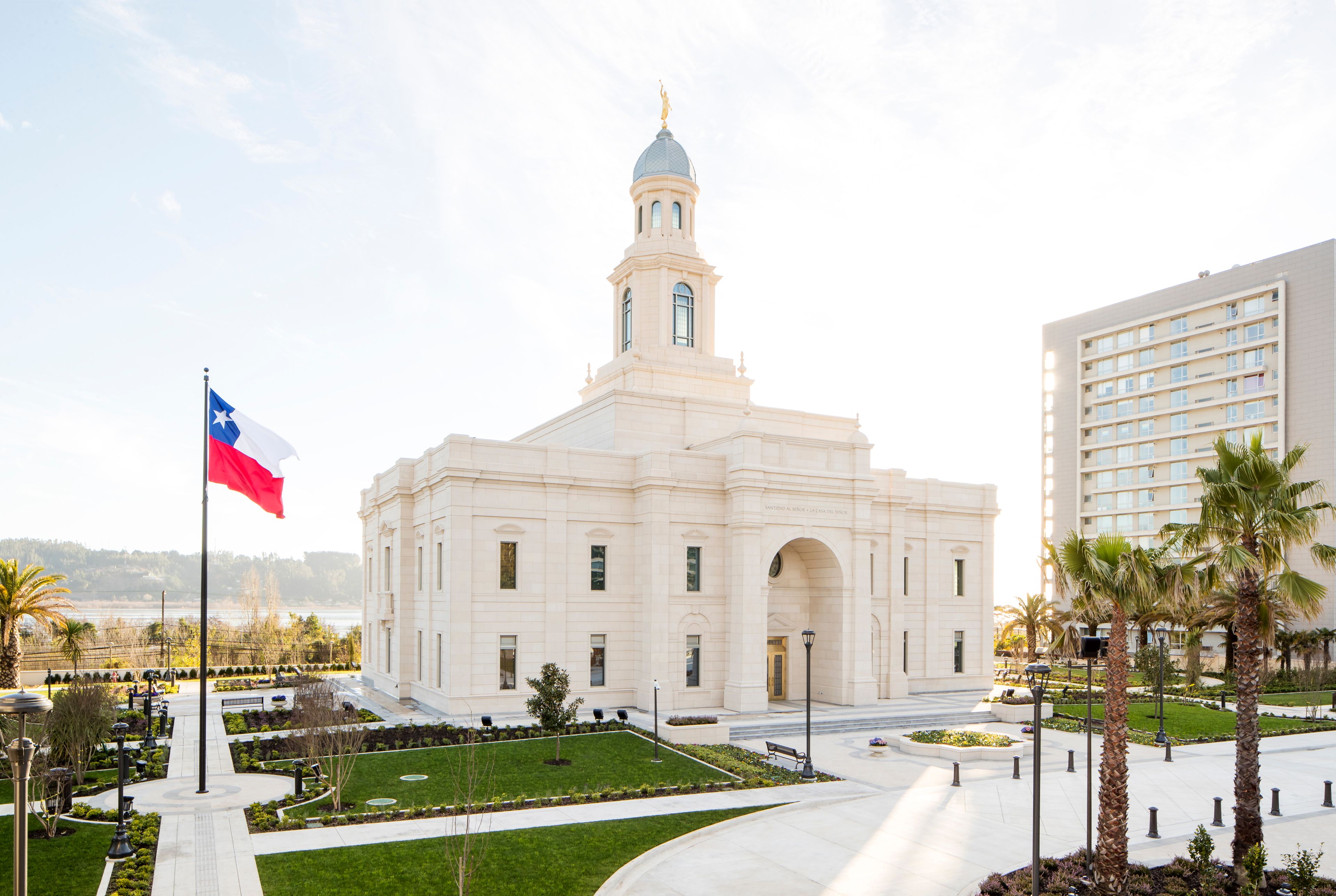 A full view of the Concepción Chile Temple with the Chilean flag displayed on the grounds.
