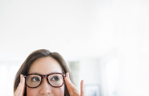 woman adjusting her eyeglasses