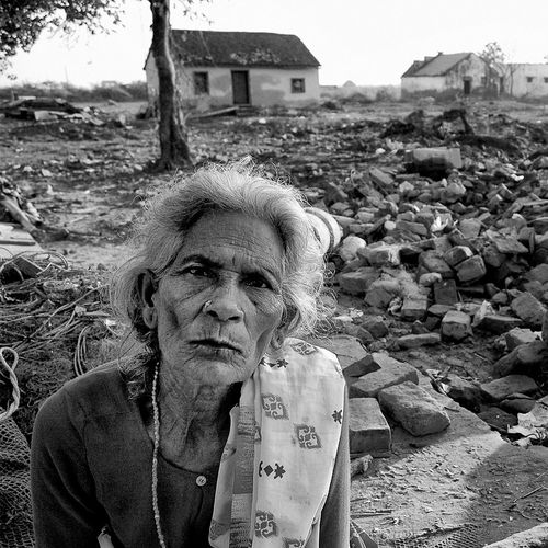 woman with rubble in background