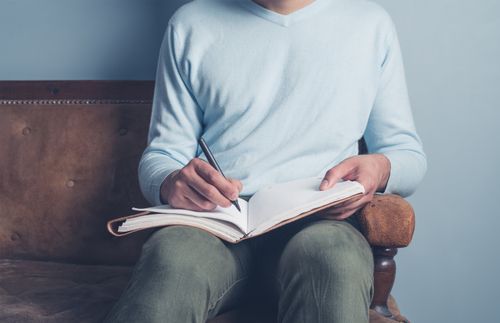 man writing in a notebook