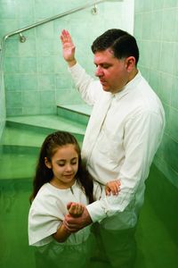 father baptizing child