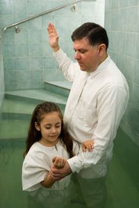 father baptizing child