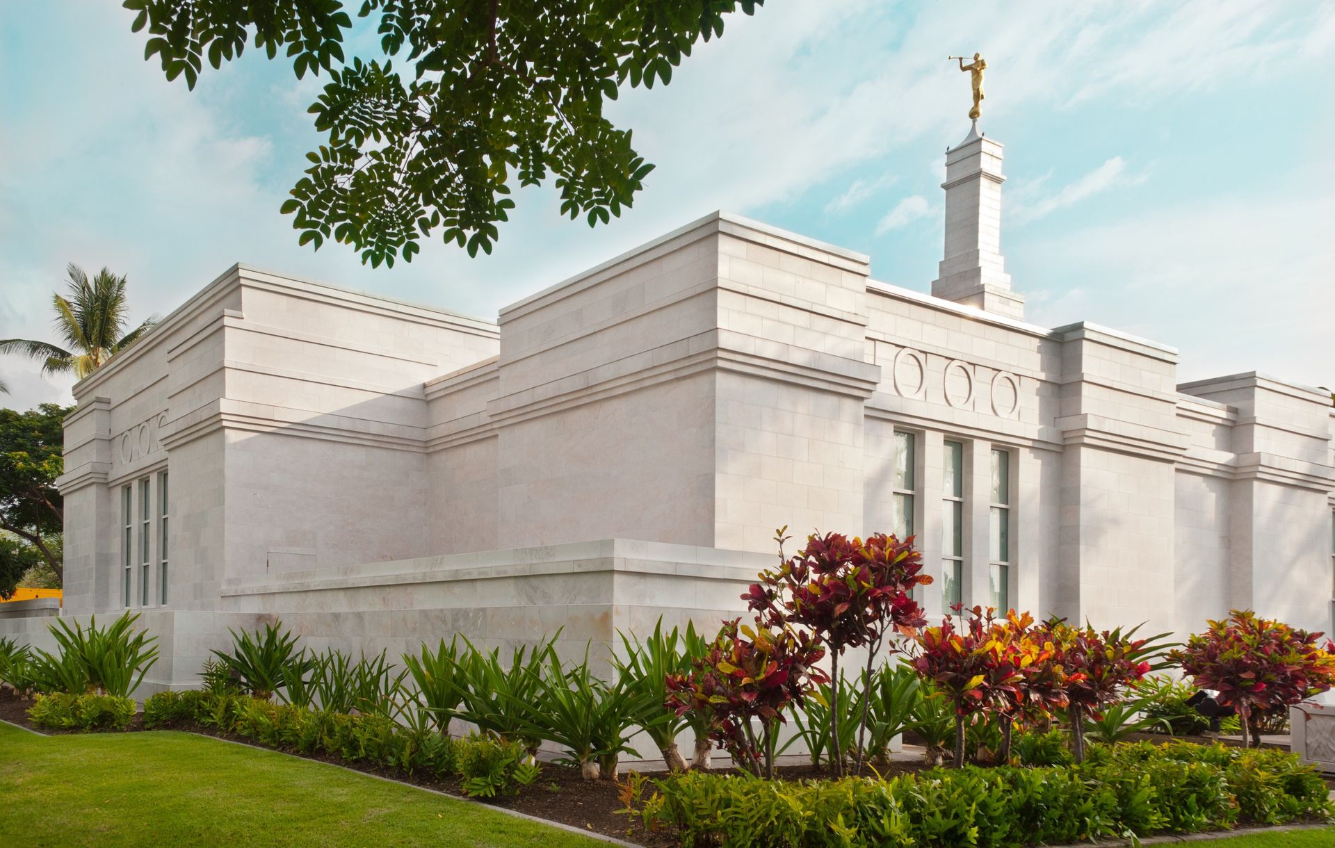 A side view of the Kona Hawaii Temple, including scenery and the exterior of the temple.