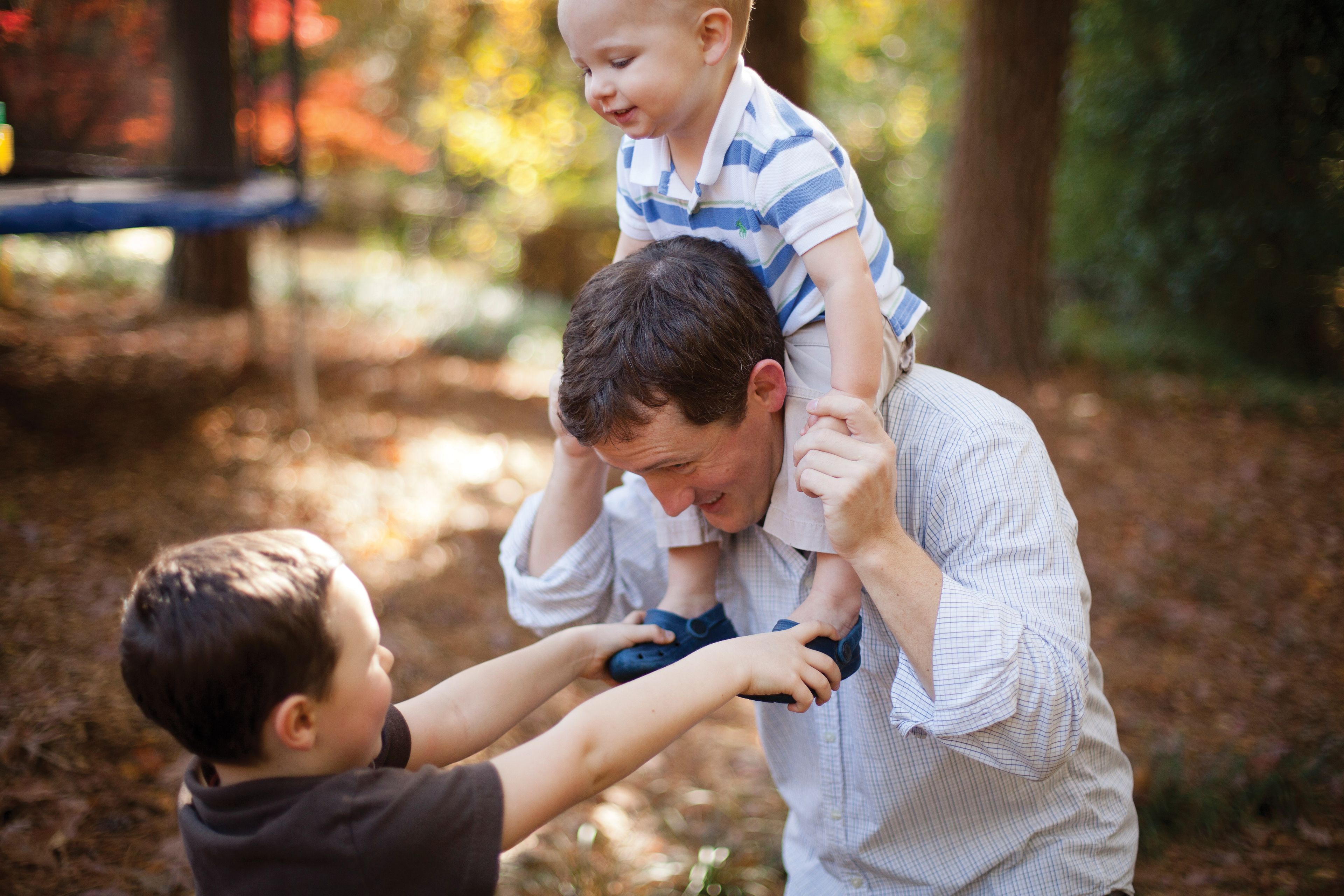 A father plays with his two young sons.