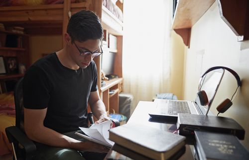 young man studying in bedroom