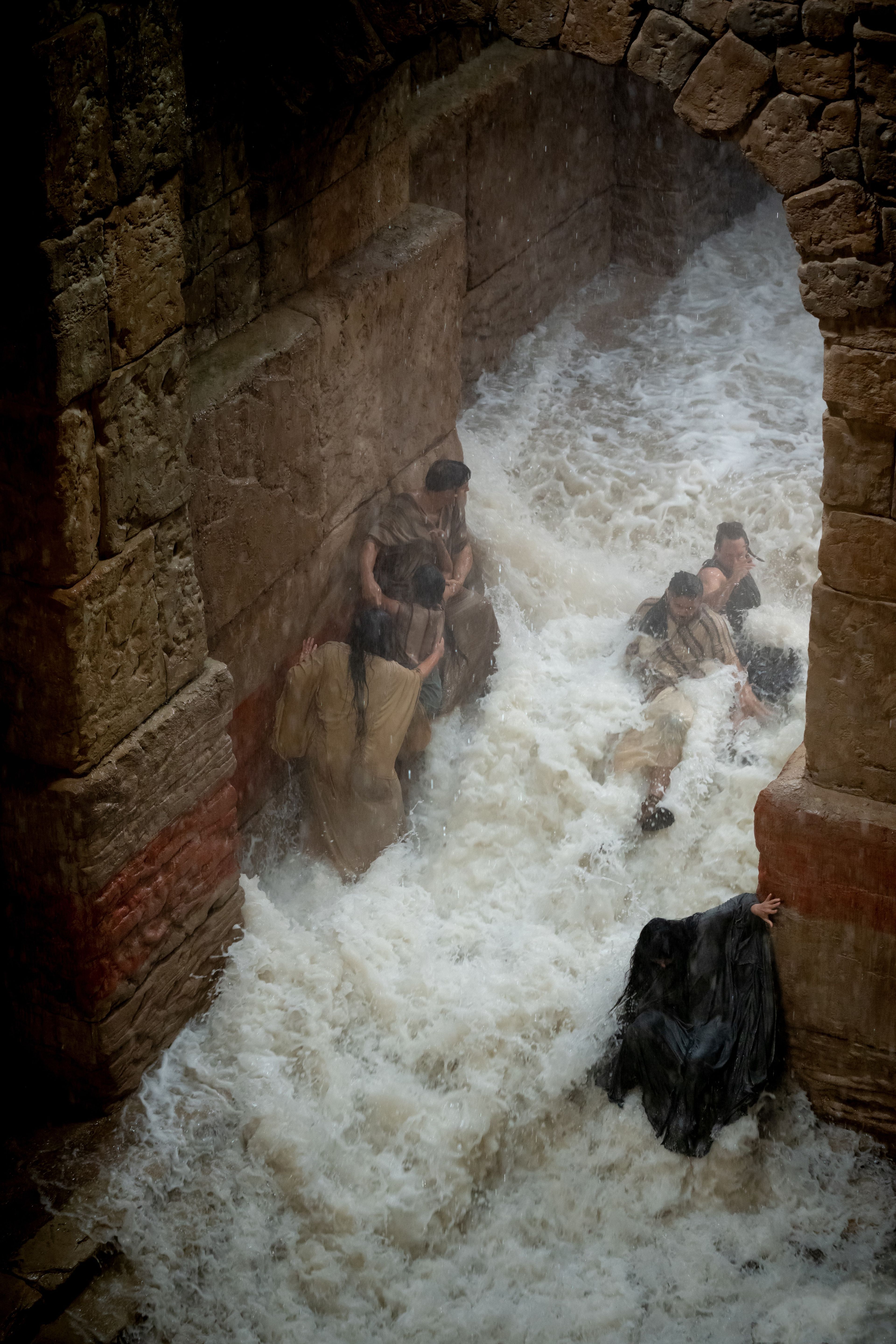 A flash flood sweeps people away, while a blind girl is rescued by her father.