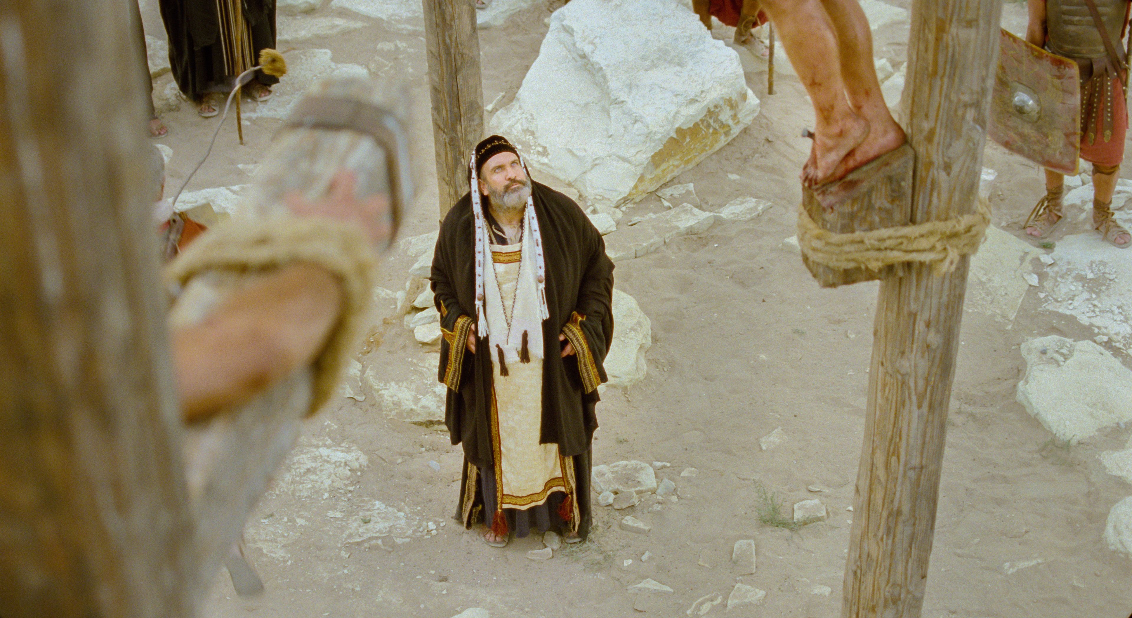 Caiaphas looks upon the Savior, who is hanging on the cross.