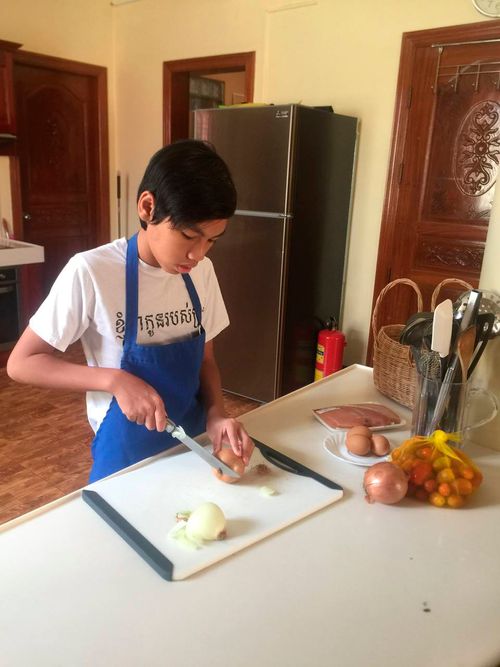 boy cutting up vegetables