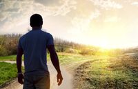 composite of young man in sillouette and landscape