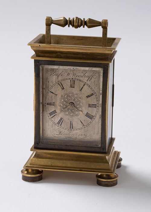 Photograph of a clock in a small ornate metal case.