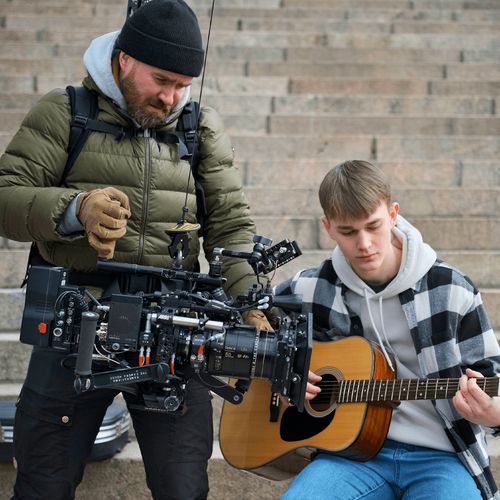 mann som filmer ung mann som spiller gitar