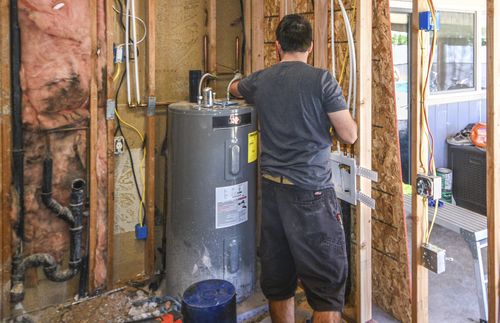 man fixing water heater