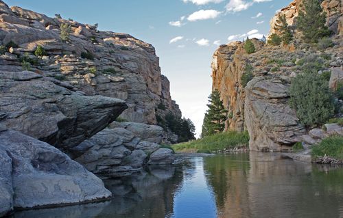 The historic site Devil’s Gate in Wyoming, consisting of tall rocky ledges lining a small body of water.