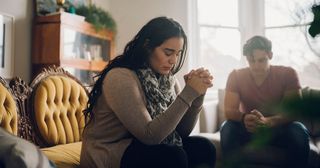 a woman prays with others