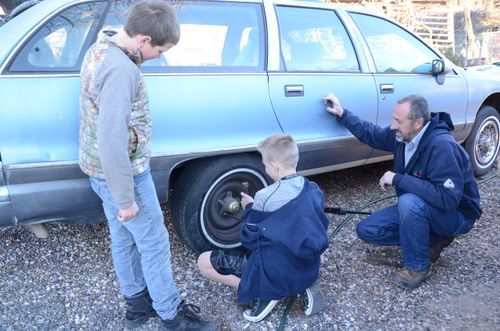 two boys learning to change a tire