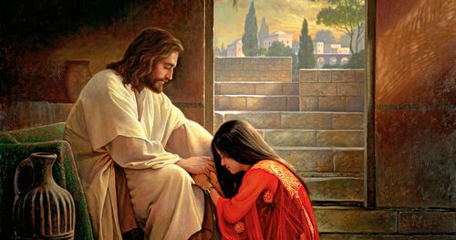 woman kneeling at Jesus’s feet