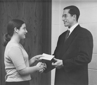 Young woman giving tithing to bishop