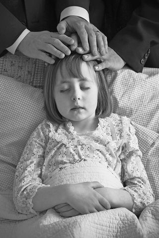 Ill child receiving blessing