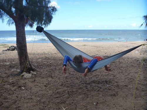 person relaxing on hammock at the beach