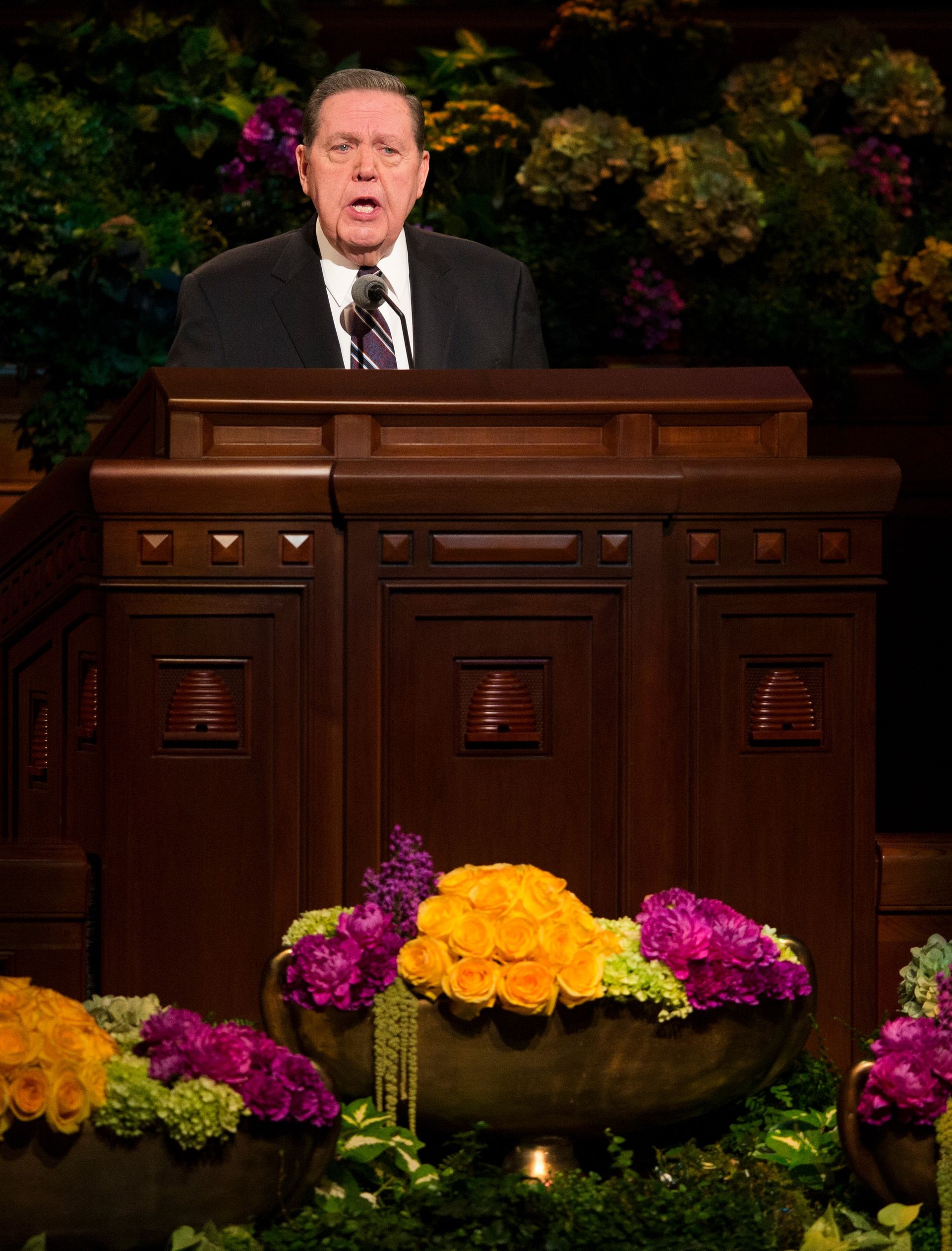 Jeffrey R. Holland standing and speaking behind the pulpit in general conference.