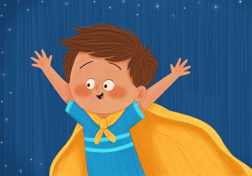 A young boy lifts his arms up in the air. He is wearing a yellow blanket as a cape. He is excited to play the Christmas star.