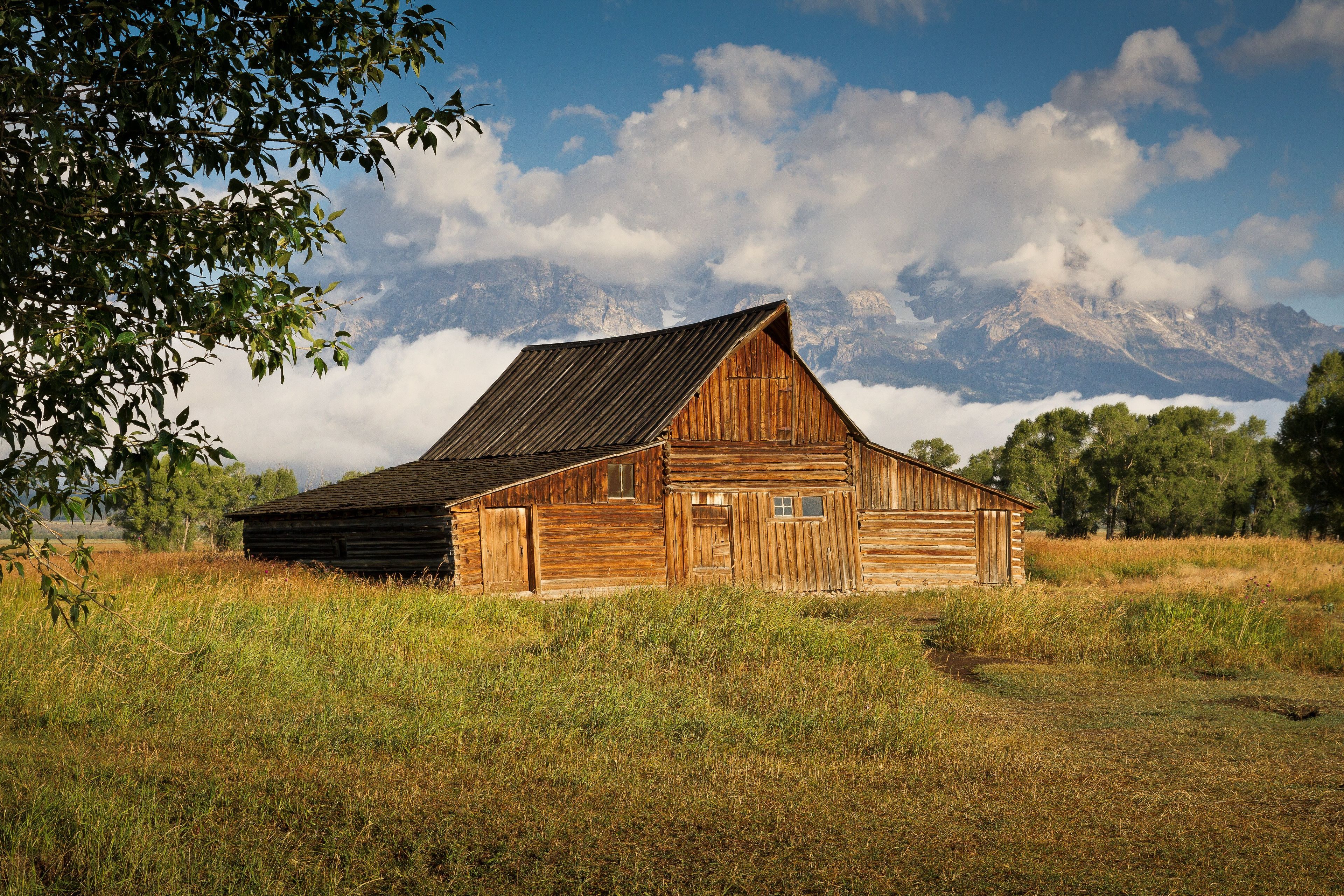 A barn with mountains in the distance.