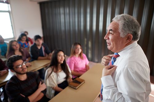 Young adult men and women can be see taking part in class and interacting with the instructor and with each other.