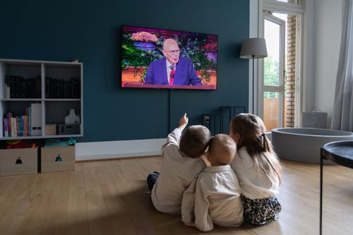 Three young children sit together and watch a session of conference together. Part of a worldwide series of photographs taken in connection with General Conference. September 30 - October 1, 2023. Pictures were taken in Denmark.