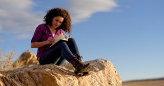 Jeune adulte écrivant dans son journal